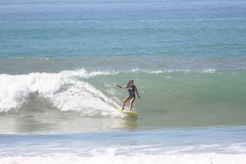 Woman catching a wave at Pura Vida Surf Camp Costa Rica
