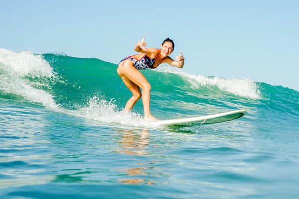 Woman Showing the Thumps Up Sign and Surfing in Costa Rica