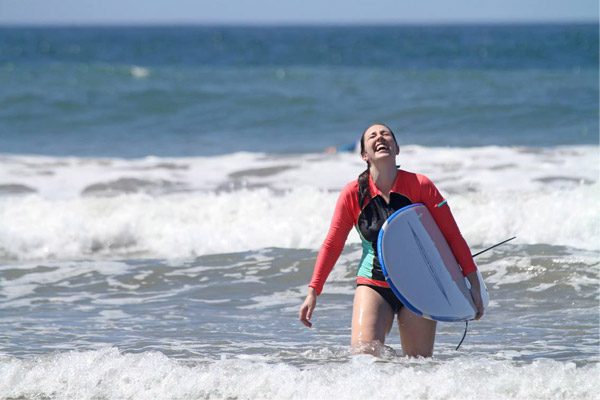 Womain Laughing and Surfing During Her Costa Rica Beach Vacation