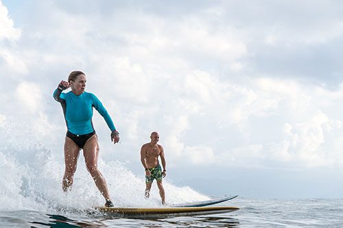 Woman 50+ surfing with instructor