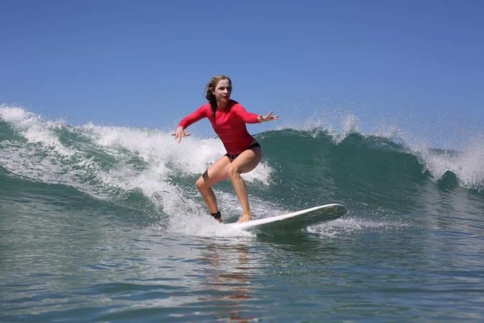 women surfing on a longboard