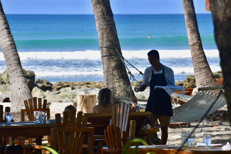 a waiter and a customer at a restaurant on the beach