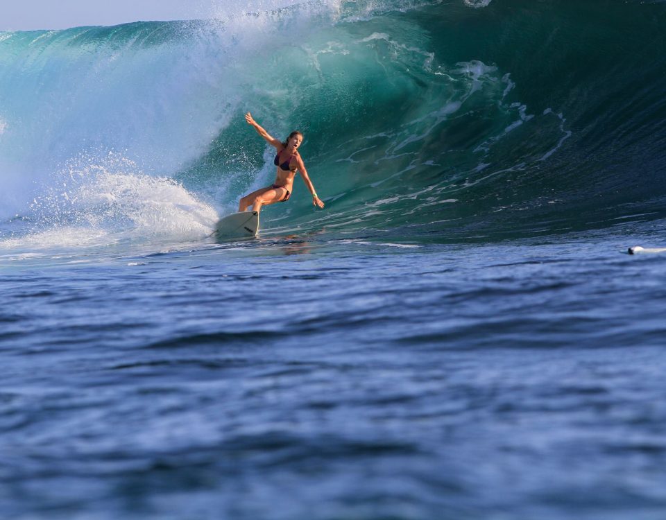 Woman surfing a large wave.