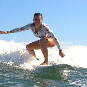 Woman surfing on a longboard in Santa Teresa, Costa Rica on a surf and yoga retreat.