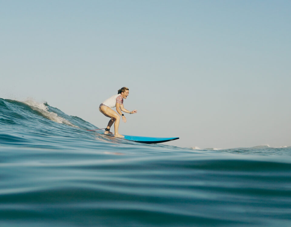 Woman over 50 surfing a wave at Pura Vida Adventures in Santa Teresa, Costa Rica